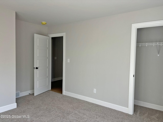 unfurnished bedroom featuring baseboards, carpet, a closet, and visible vents