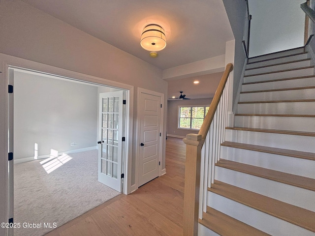 stairs featuring baseboards, carpet flooring, and wood finished floors