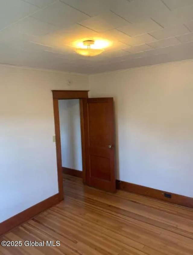 unfurnished room featuring baseboards and light wood finished floors