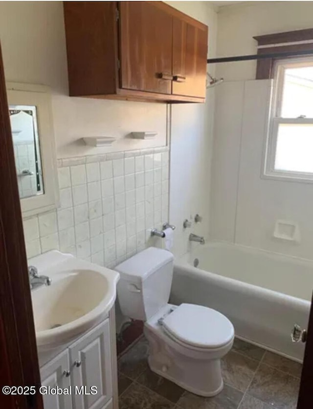 full bathroom with vanity, toilet, bathtub / shower combination, and tile walls