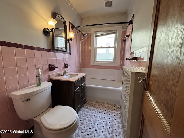 full bath with tile patterned floors, tile walls, toilet, vanity, and visible vents