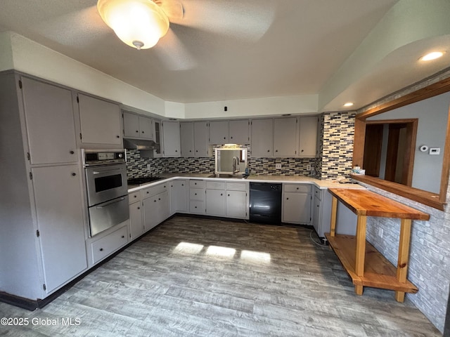kitchen featuring a sink, gray cabinets, black appliances, light countertops, and dark wood finished floors