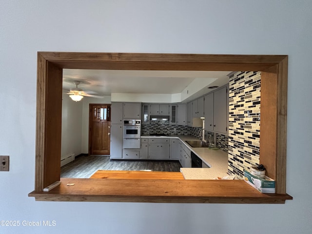 kitchen featuring tasteful backsplash, a baseboard heating unit, black appliances, a warming drawer, and gray cabinets