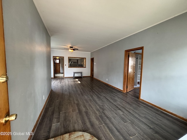 unfurnished living room with dark wood-style floors, baseboards, and ornamental molding
