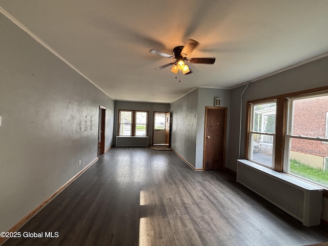 unfurnished living room with dark wood finished floors, baseboards, radiator, and a ceiling fan