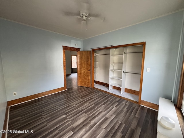 unfurnished bedroom featuring a closet, ornamental molding, dark wood finished floors, and baseboards