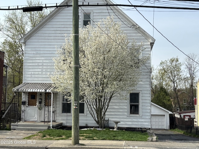 view of front of property with a detached garage and fence