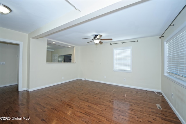 spare room with wood finished floors, visible vents, baseboards, and ceiling fan
