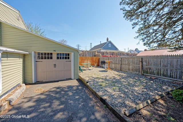 view of yard with a garage, fence, and an outdoor structure