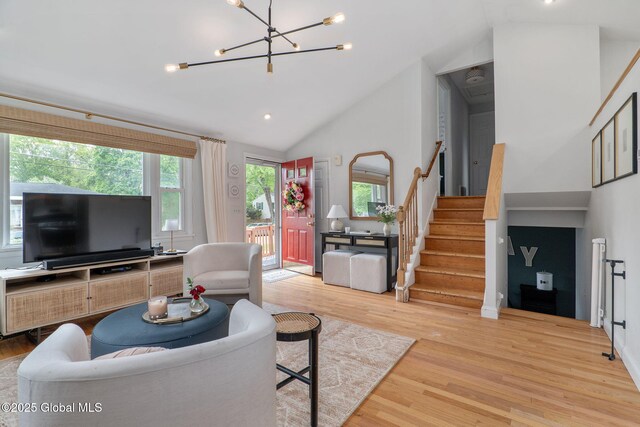 21 St Charles Pl, Saratoga Springs, NY 12866 - living room featuring stairs, plenty of natural light, light wood finished floors, a chandelier, and high vaulted ceiling