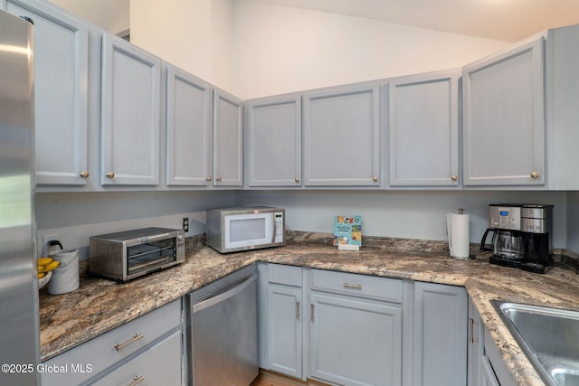 21 St Charles Pl, Saratoga Springs, NY 12866 - kitchen featuring stainless steel appliances, gray cabinetry, a sink, and dark stone countertops