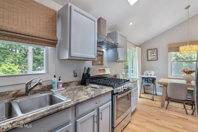 21 St Charles Pl, Saratoga Springs, NY 12866 - kitchen featuring gas range, a sink, wall chimney exhaust hood, light wood finished floors, and decorative light fixtures