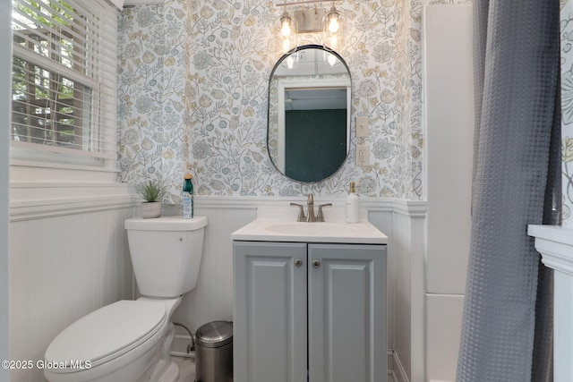 21 St Charles Pl, Saratoga Springs, NY 12866 - bathroom with wallpapered walls, a wainscoted wall, toilet, vanity, and a shower with shower curtain