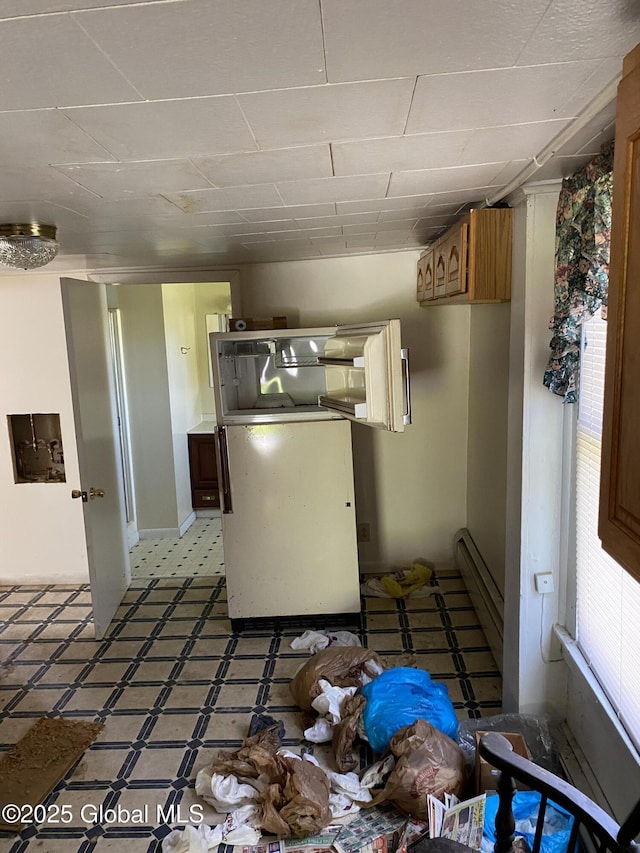 kitchen featuring light floors and a drop ceiling