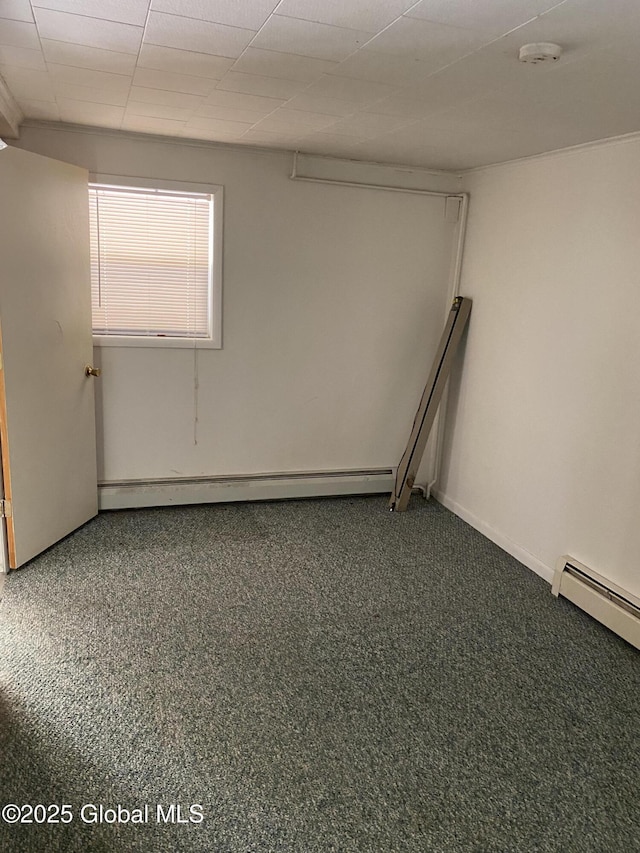 carpeted spare room featuring baseboard heating