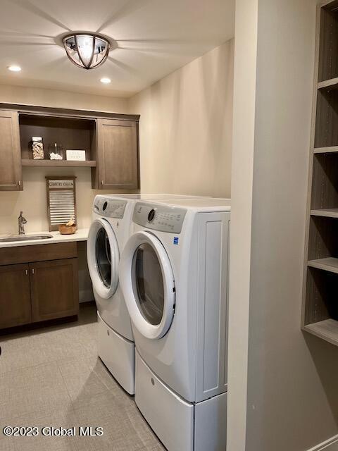 laundry room with light tile patterned floors, independent washer and dryer, a sink, recessed lighting, and cabinet space