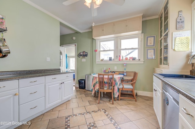 kitchen featuring stainless steel dishwasher, a sink, ceiling fan, baseboards, and ornamental molding