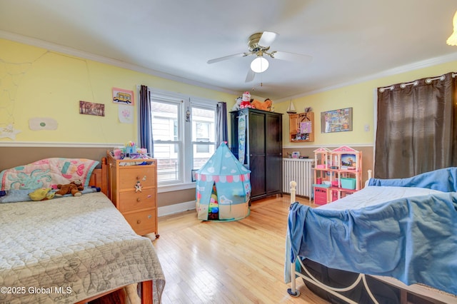 bedroom featuring ceiling fan, light wood-type flooring, and ornamental molding