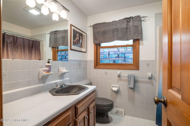 63 Pawling Ave, Mechanicville, NY 12118 - bathroom with tile walls, vanity, toilet, a wainscoted wall, and visible vents