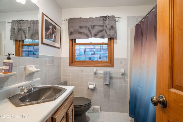 63 Pawling Ave, Mechanicville, NY 12118 - full bath with vanity, toilet, a wainscoted wall, and tile walls