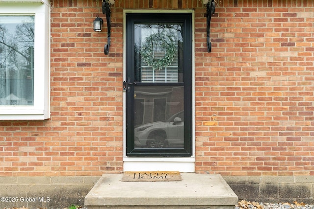 view of exterior entry with brick siding
