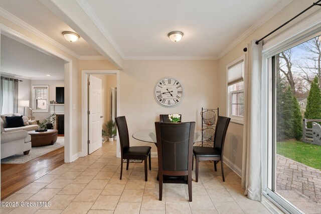dining room featuring baseboards, ornamental molding, and light tile patterned floors