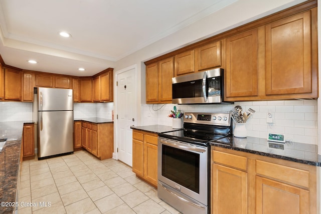 kitchen with light tile patterned floors, backsplash, stainless steel appliances, and brown cabinetry