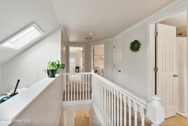 hall with a skylight and an upstairs landing