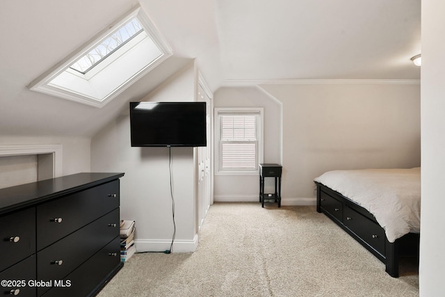 carpeted bedroom featuring baseboards and vaulted ceiling with skylight