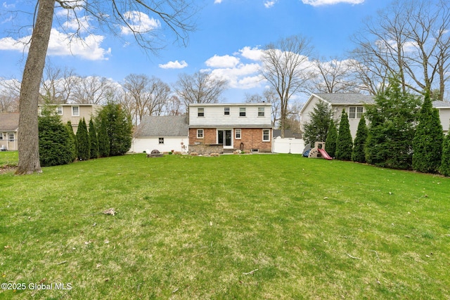 exterior space featuring a lawn, brick siding, fence, and entry steps