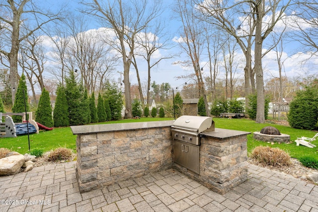 view of patio featuring area for grilling, an outdoor kitchen, and an outdoor fire pit