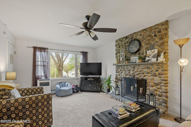 carpeted living room featuring a stone fireplace, heating unit, ceiling fan, and a baseboard heating unit