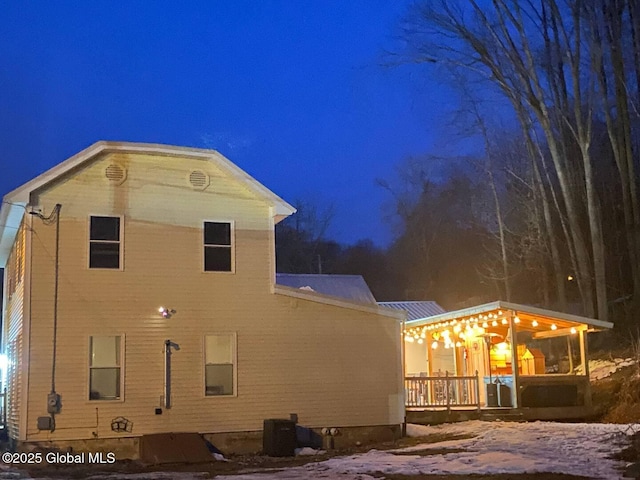 back of house at twilight featuring a wooden deck