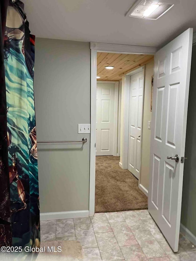 corridor with light carpet and baseboards