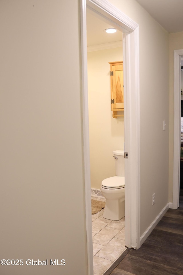 bathroom with wood finished floors, toilet, and baseboards