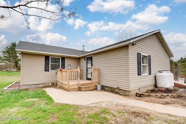 view of front of home featuring a patio, a front lawn, and a wooden deck