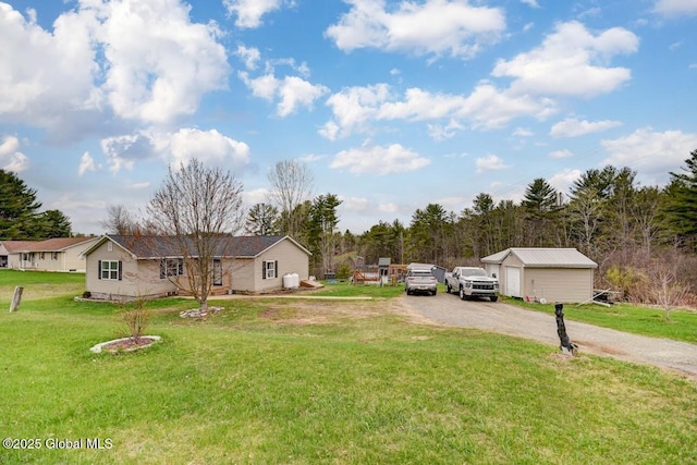 view of front of house featuring driveway, an outbuilding, and a front yard
