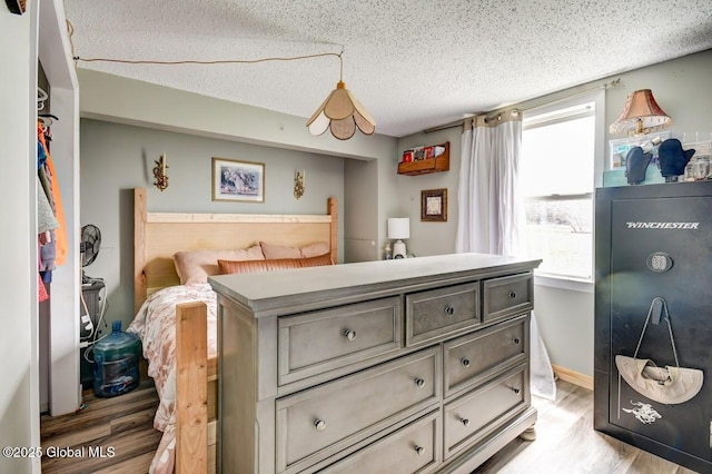 bedroom featuring light wood-style floors and a textured ceiling