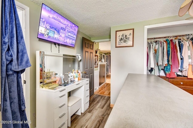 bedroom featuring a closet, a textured ceiling, and wood finished floors