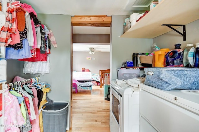 laundry room featuring a ceiling fan, laundry area, washing machine and dryer, and wood finished floors