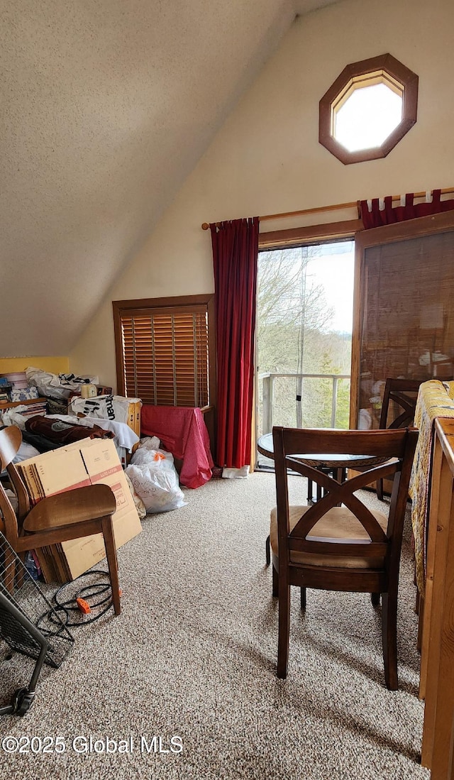 carpeted bedroom featuring a textured ceiling, vaulted ceiling, and access to outside