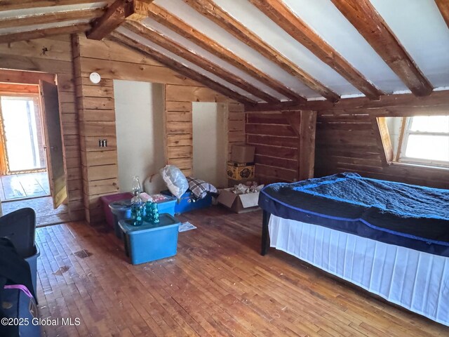 bedroom with wood-type flooring, wood walls, and vaulted ceiling with beams