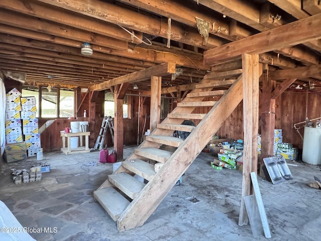 below grade area with stairs, water heater, and wood walls