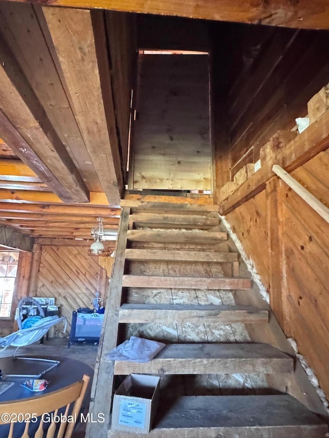 staircase featuring wood walls