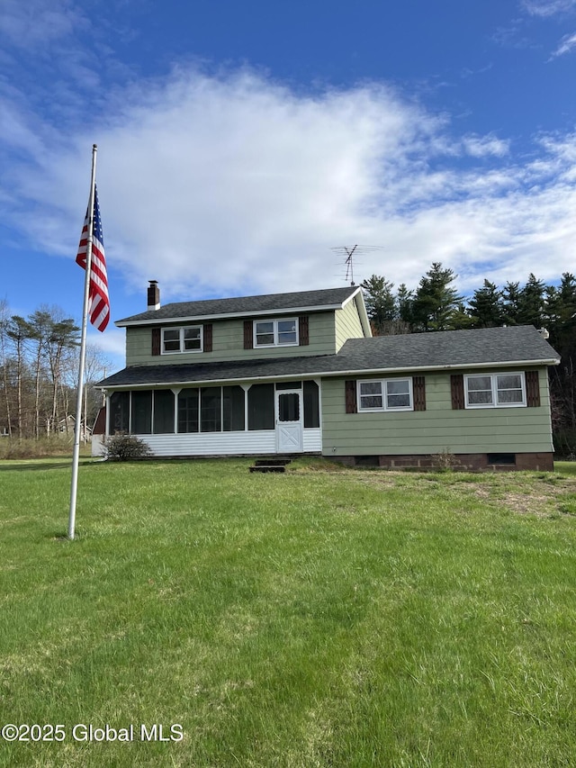 view of front of house with a front yard, a chimney, and a sunroom