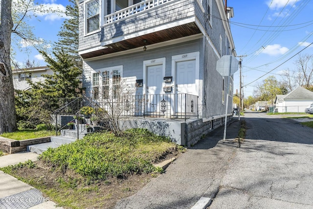 1261-1263 The Plz, Schenectady, NY 12308 - property entrance featuring a balcony, asphalt driveway, and a porch