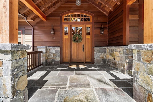 entrance to property featuring stone siding and covered porch