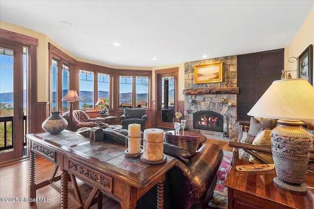 dining area featuring wood finished floors, a wealth of natural light, a stone fireplace, and recessed lighting