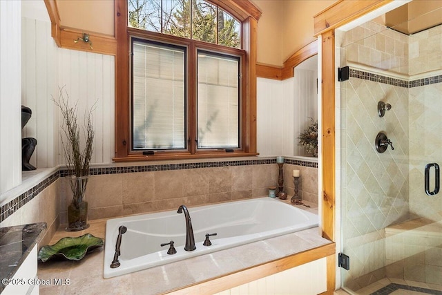 full bath featuring a stall shower and a garden tub