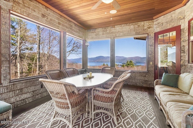 sunroom with a mountain view, outdoor lounge area, wooden ceiling, and ceiling fan